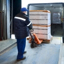 Moving palletized cartons off a truck into storage